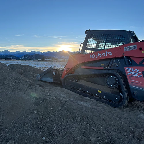 Skid Steer moving dirt in preparation for a road